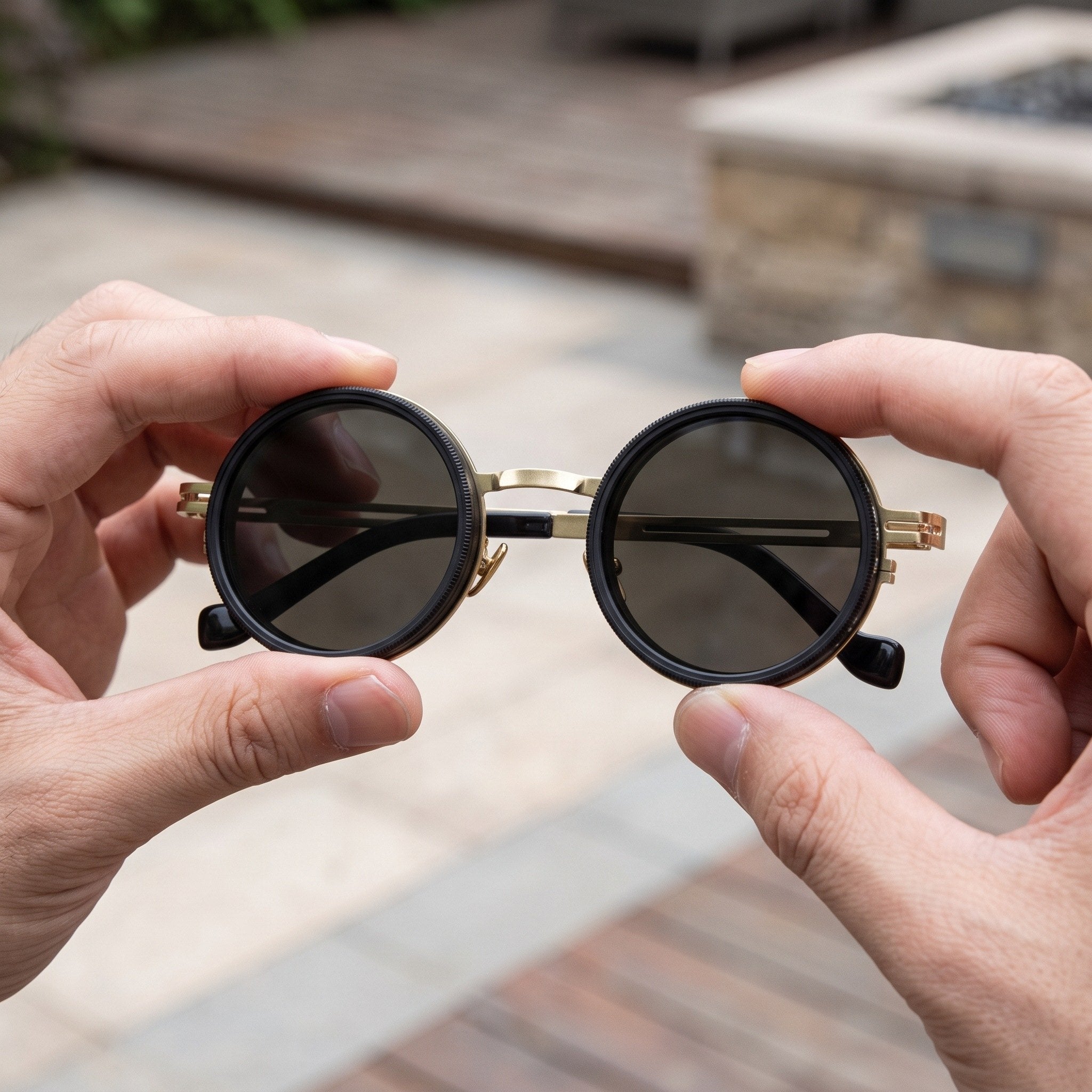 Fingers turning the round rim of Gold Shadewell sunglasses