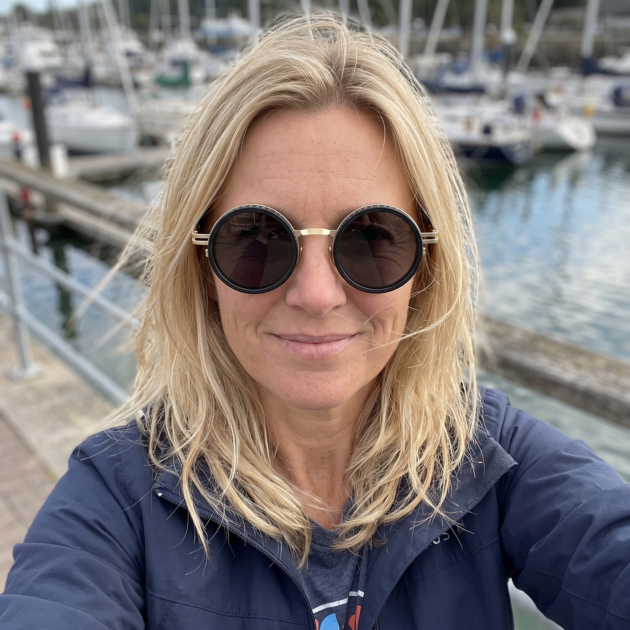 Gold sunglasses worn in a marina selfie