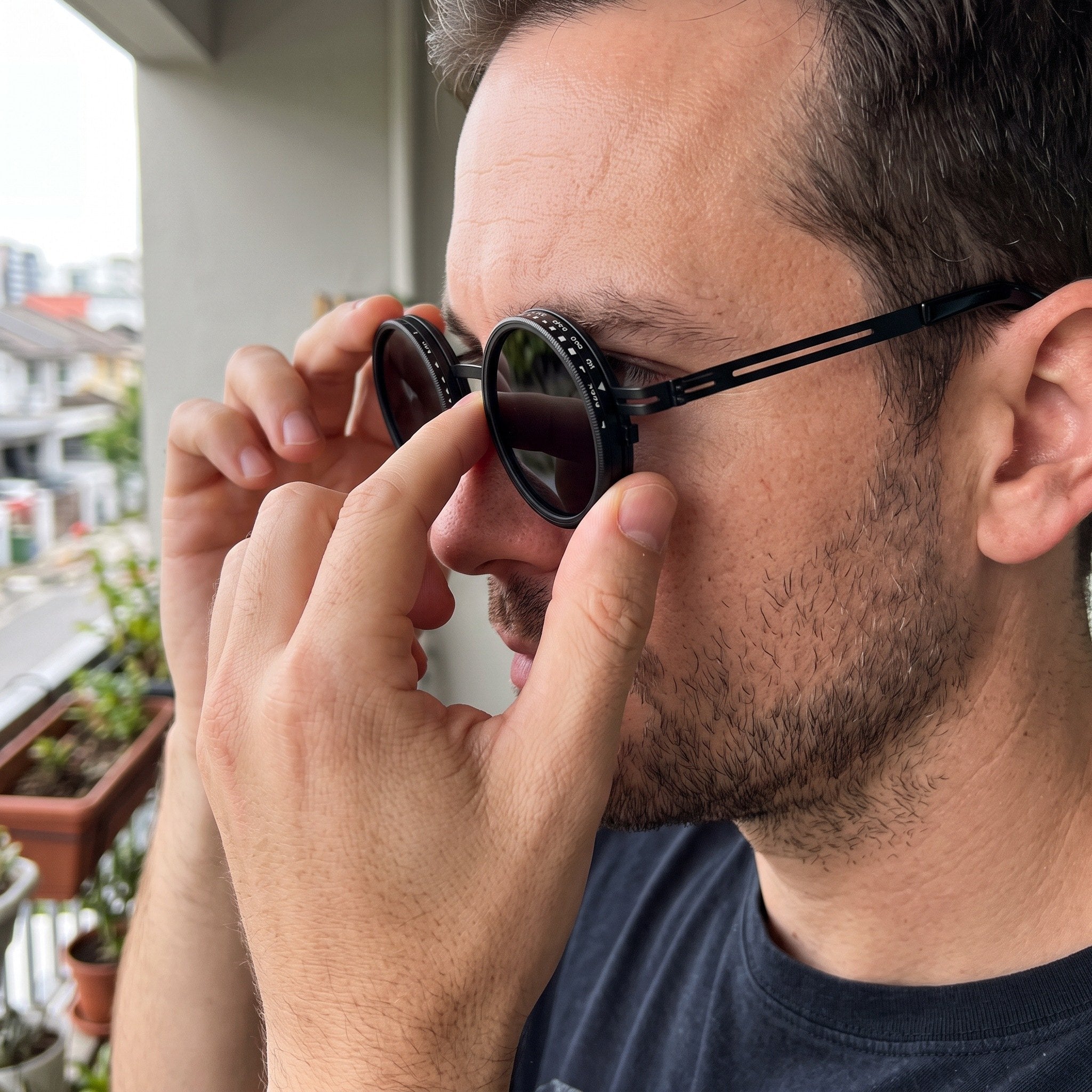 Black sunglasses adjusted on a shaded balcony