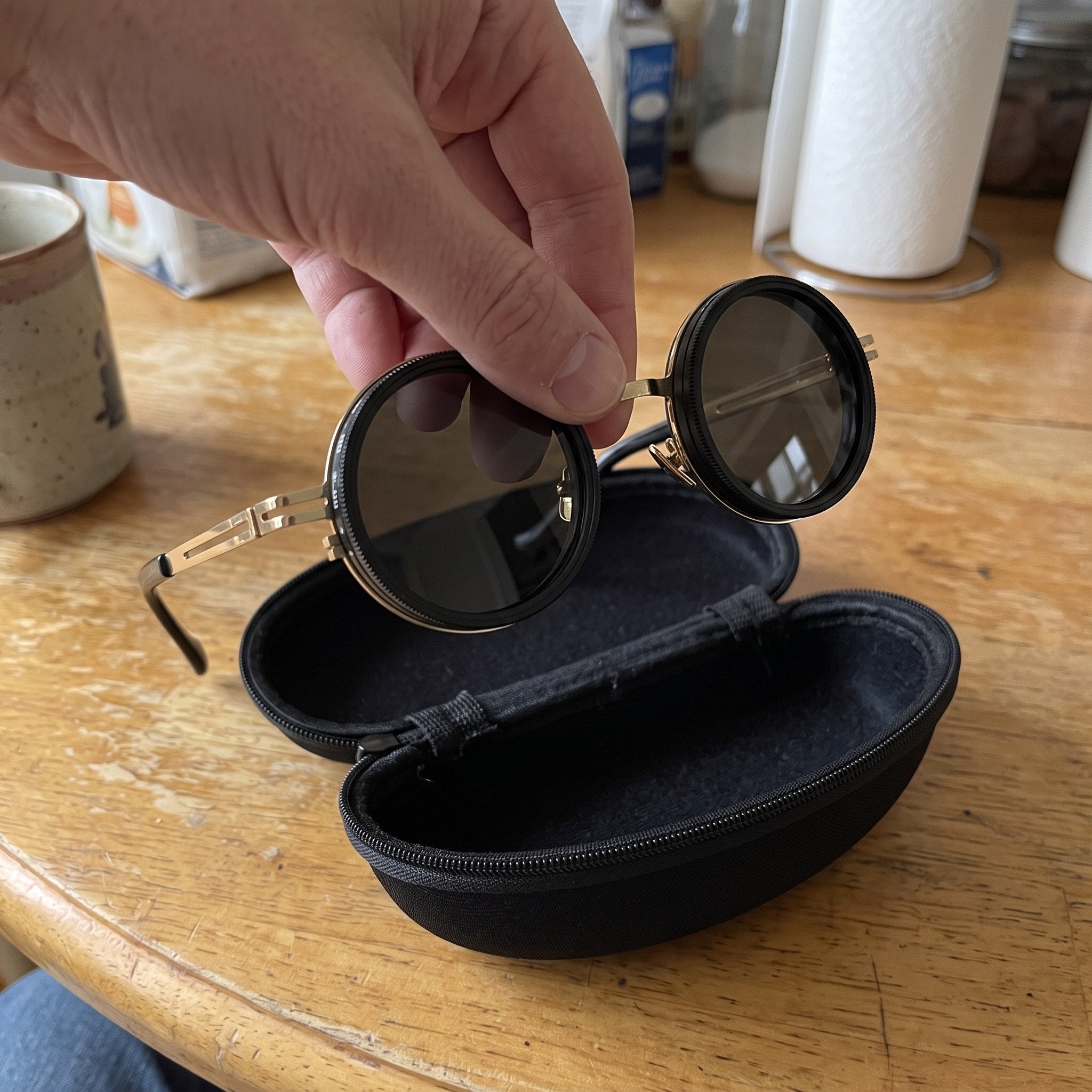 Gold sunglasses lifted from their open black case