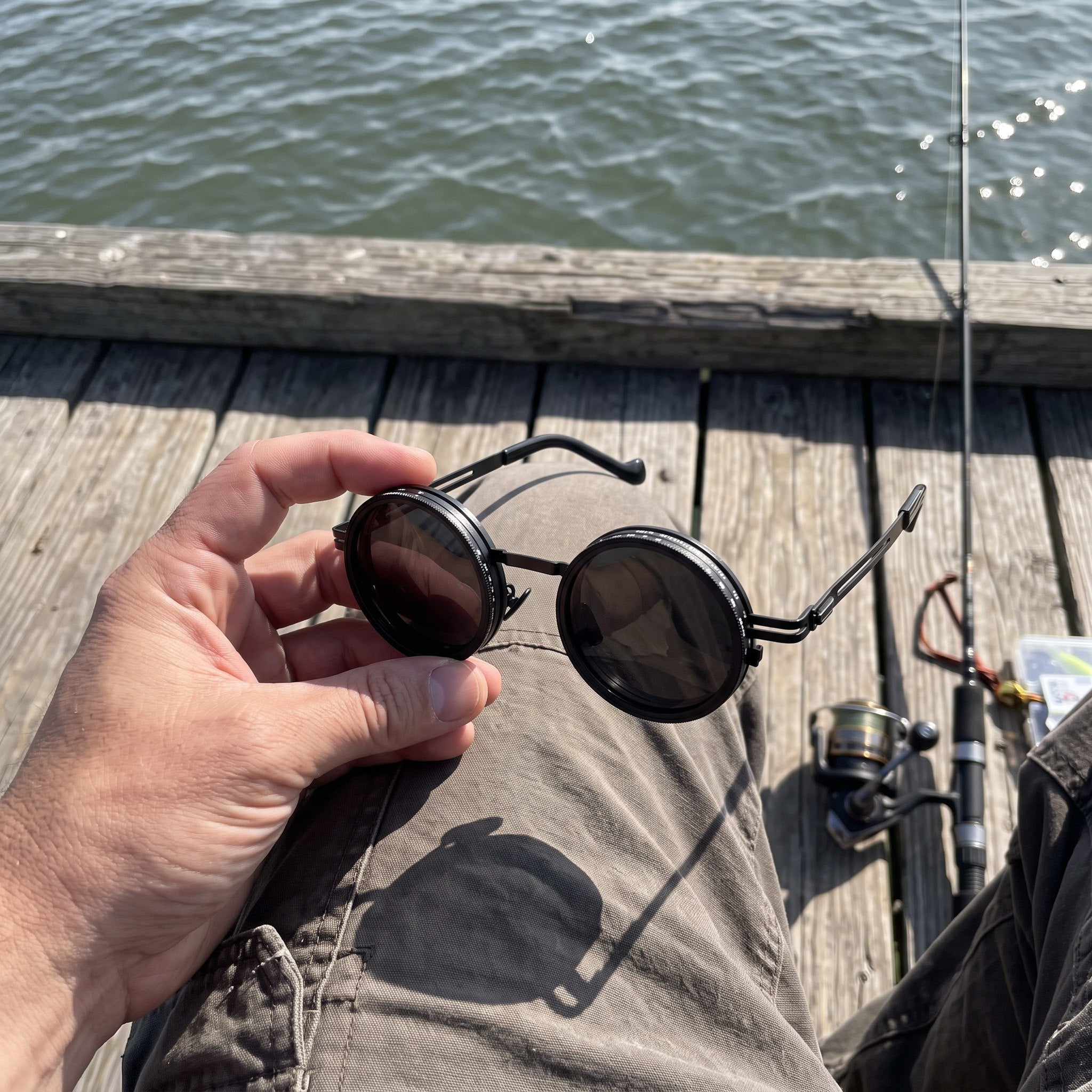 J.K. holding Black Shadewell sunglasses beside fishing gear